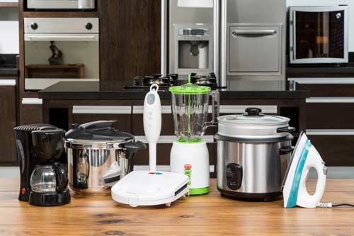 Numerous home appliances are sitting on the kitchen counter.